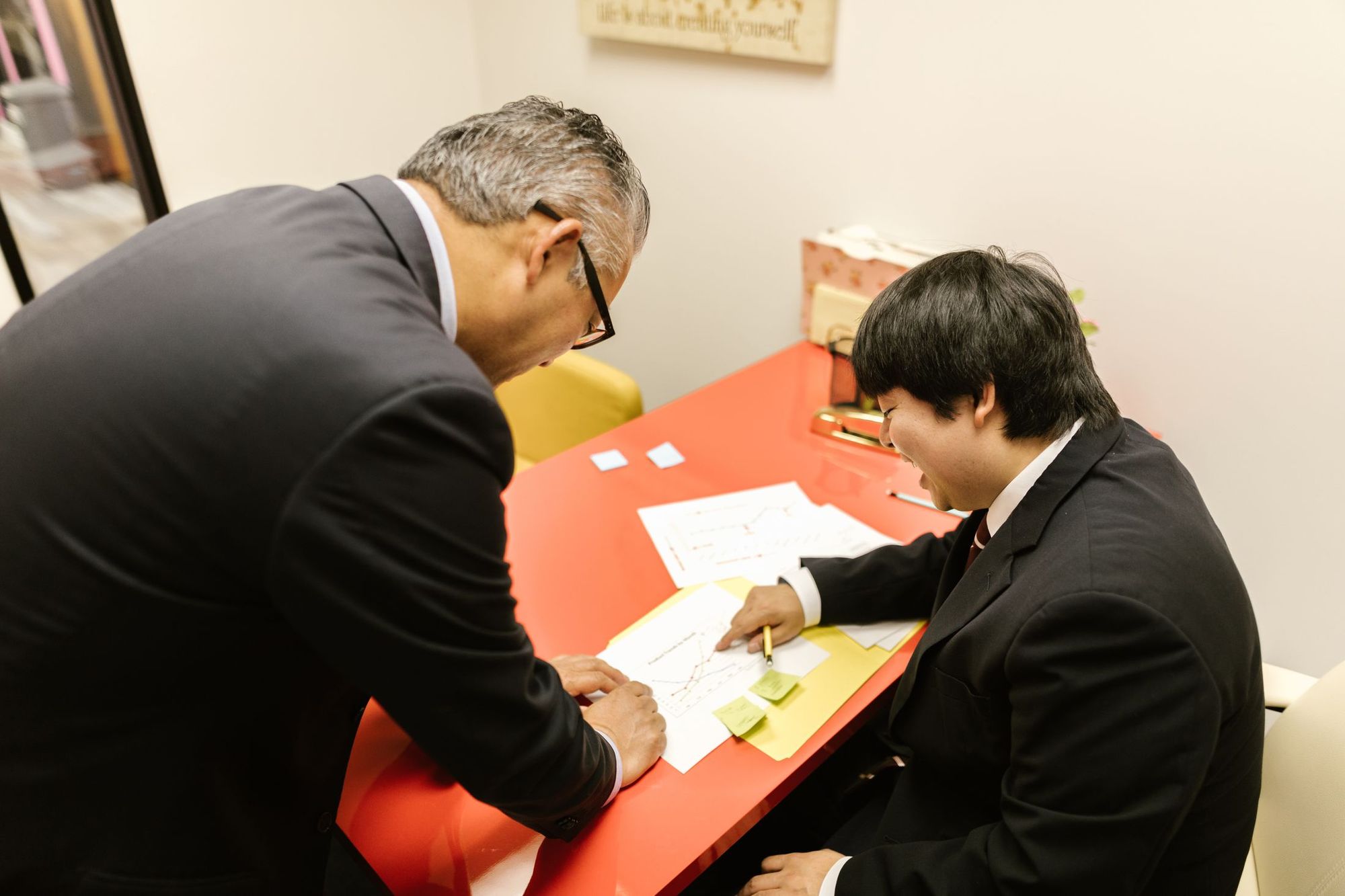 印刷した資料を前に打ち合わせをする二人